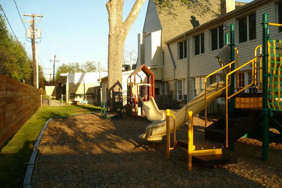 Playground with slides and climbing structures next to a building