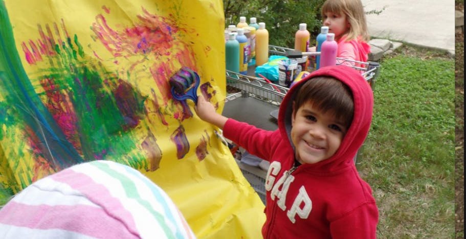 Child painting on a yellow surface