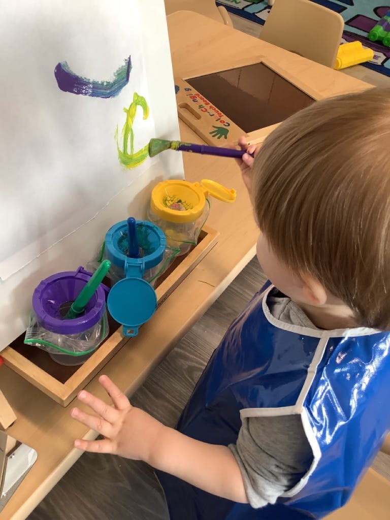 Child painting on an easel