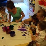 Adults and children doing crafts at a table