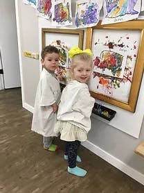 Two children looking at artwork on a wall