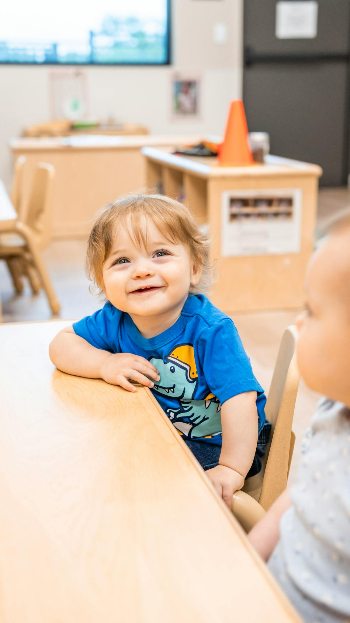 Child sitting at a table in a classroom