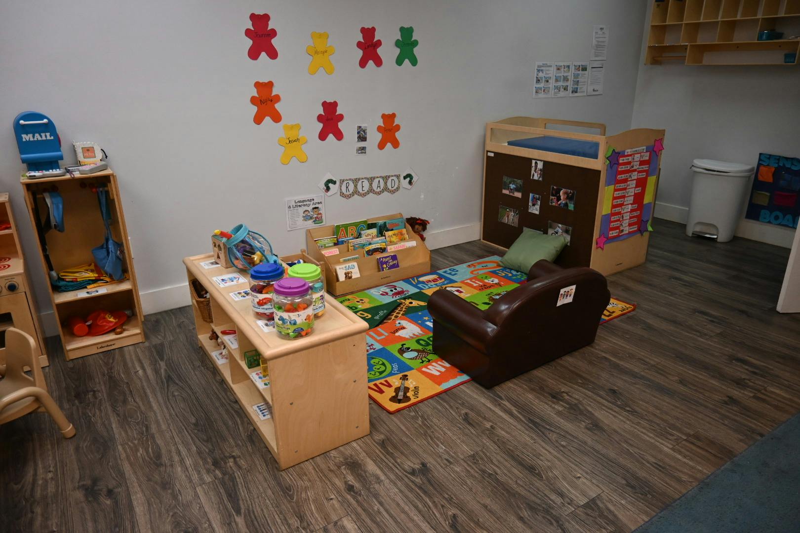Playroom with wooden shelves, colorful rug, and teddy bear wall decorations
