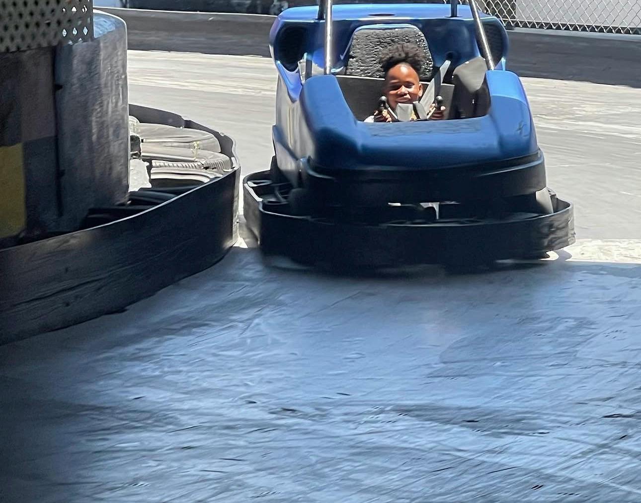 Child driving a bumper car on a track