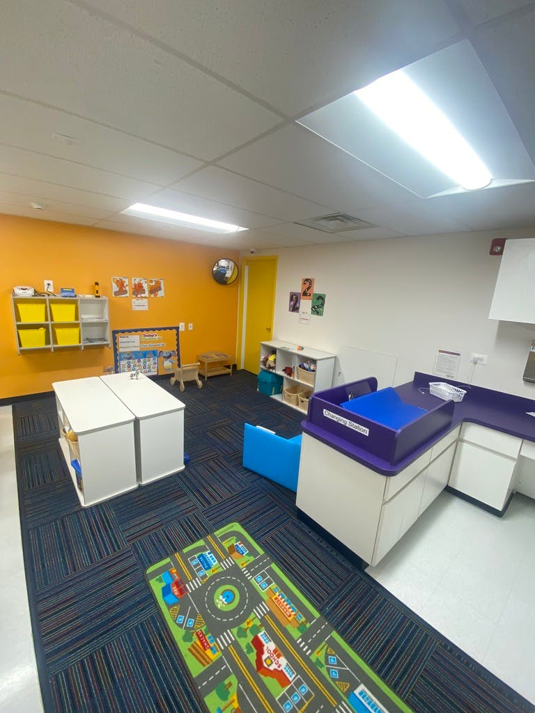 Empty classroom with play rug and changing station