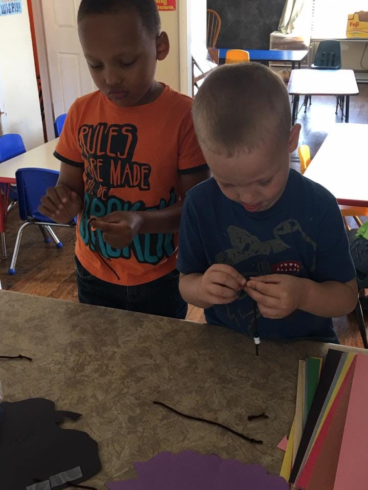 Two children working on crafts at a table