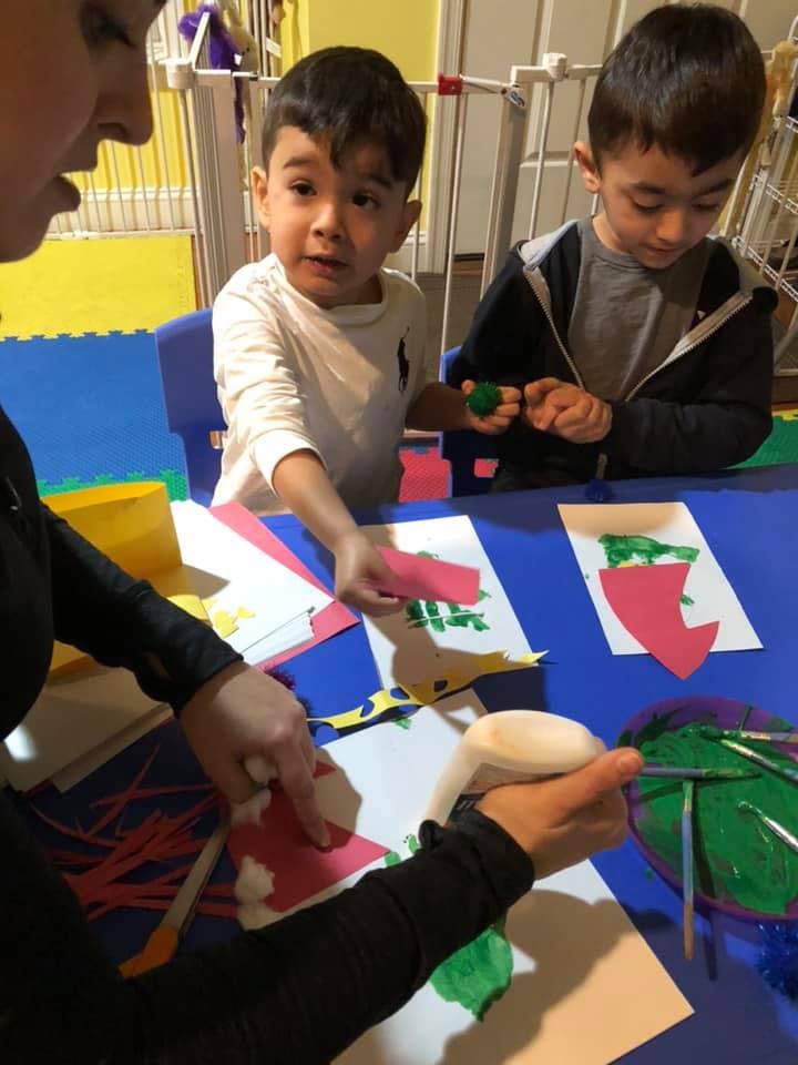 Person and two children doing crafts at a table