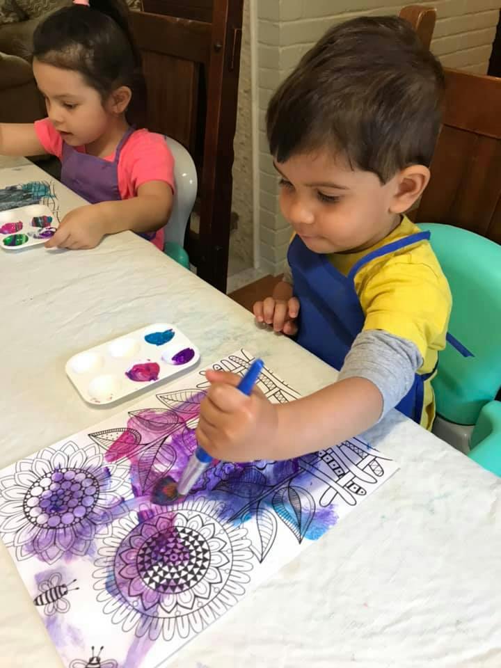 Two children painting at a table