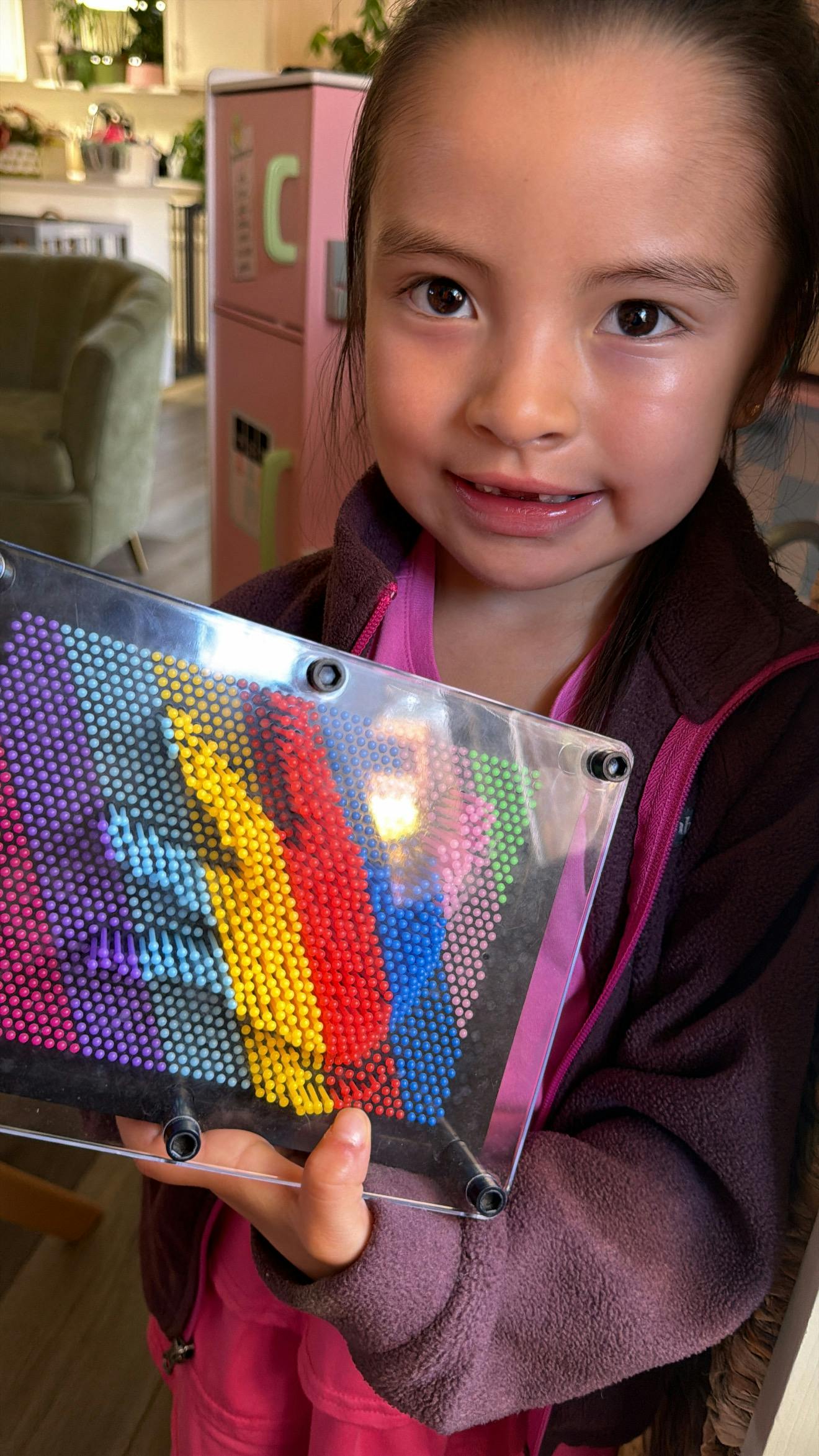 Child holding a colorful pin art toy