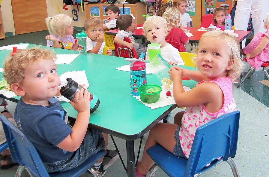 Children sitting at tables in a classroom
