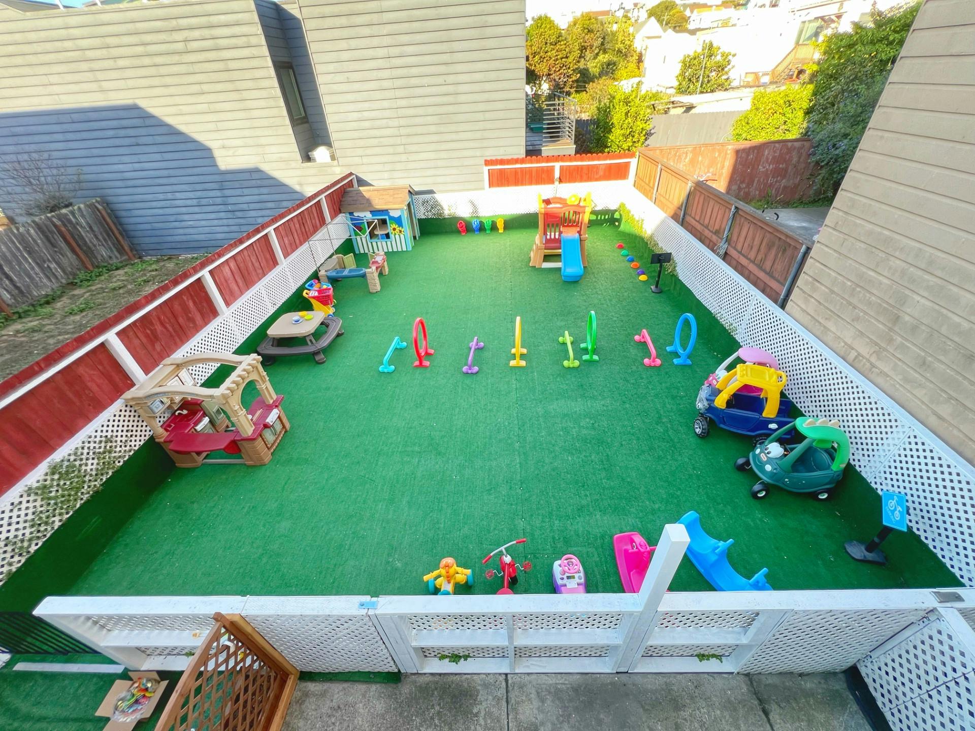 Outdoor play area with artificial turf and various toys