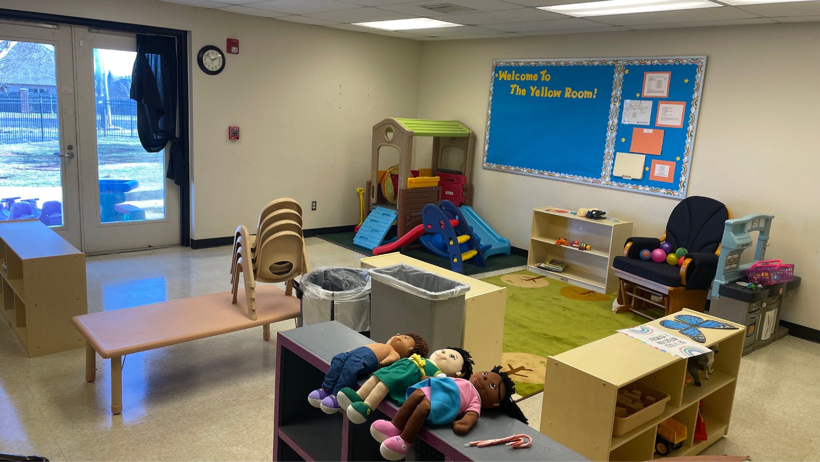 Empty classroom with play furniture and a blue bulletin board
