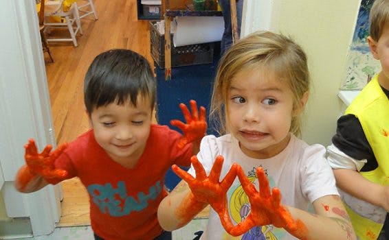 Two children with orange paint on their hands