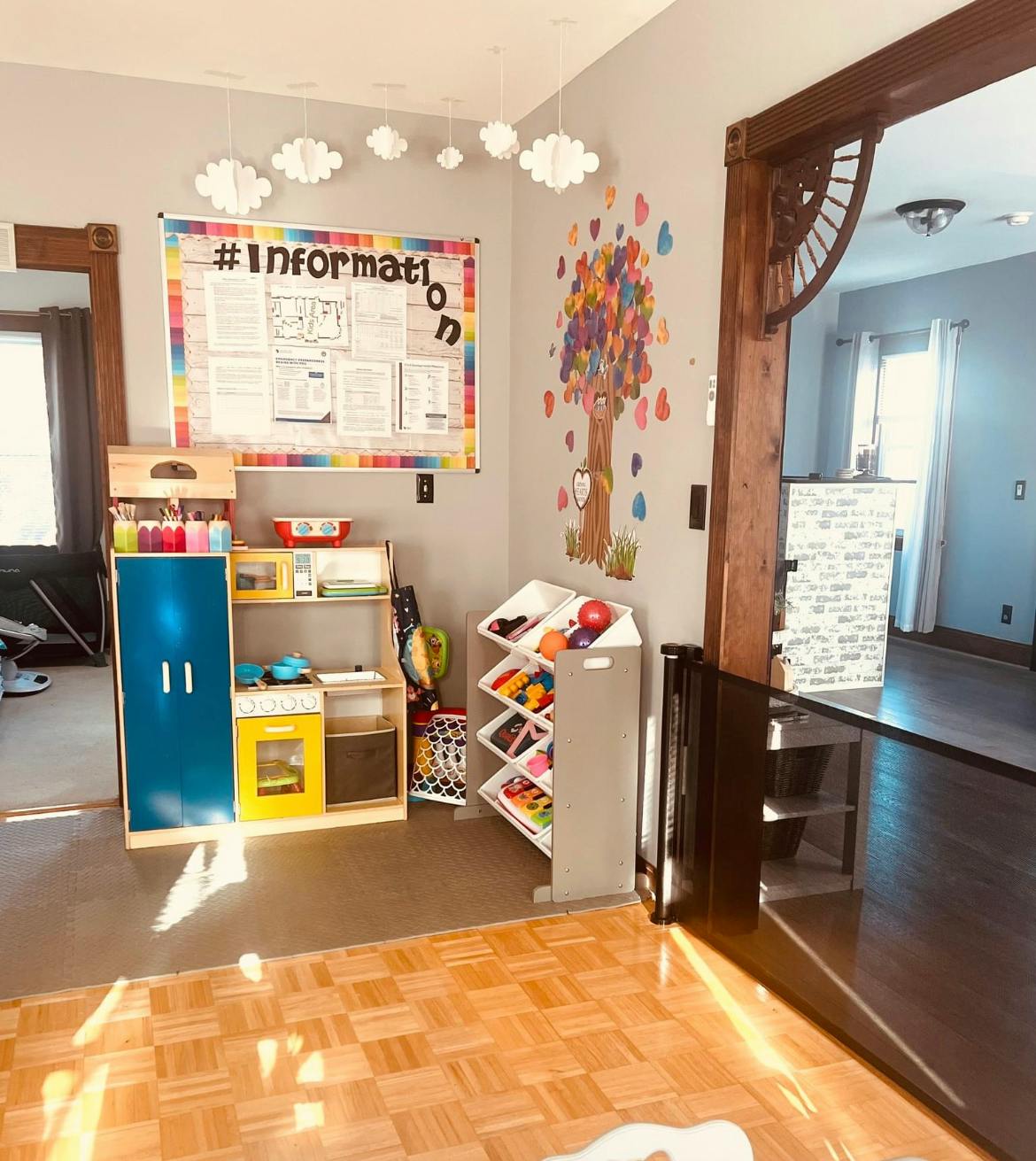 Playroom with a bulletin board, toy kitchen, and toy storage shelves