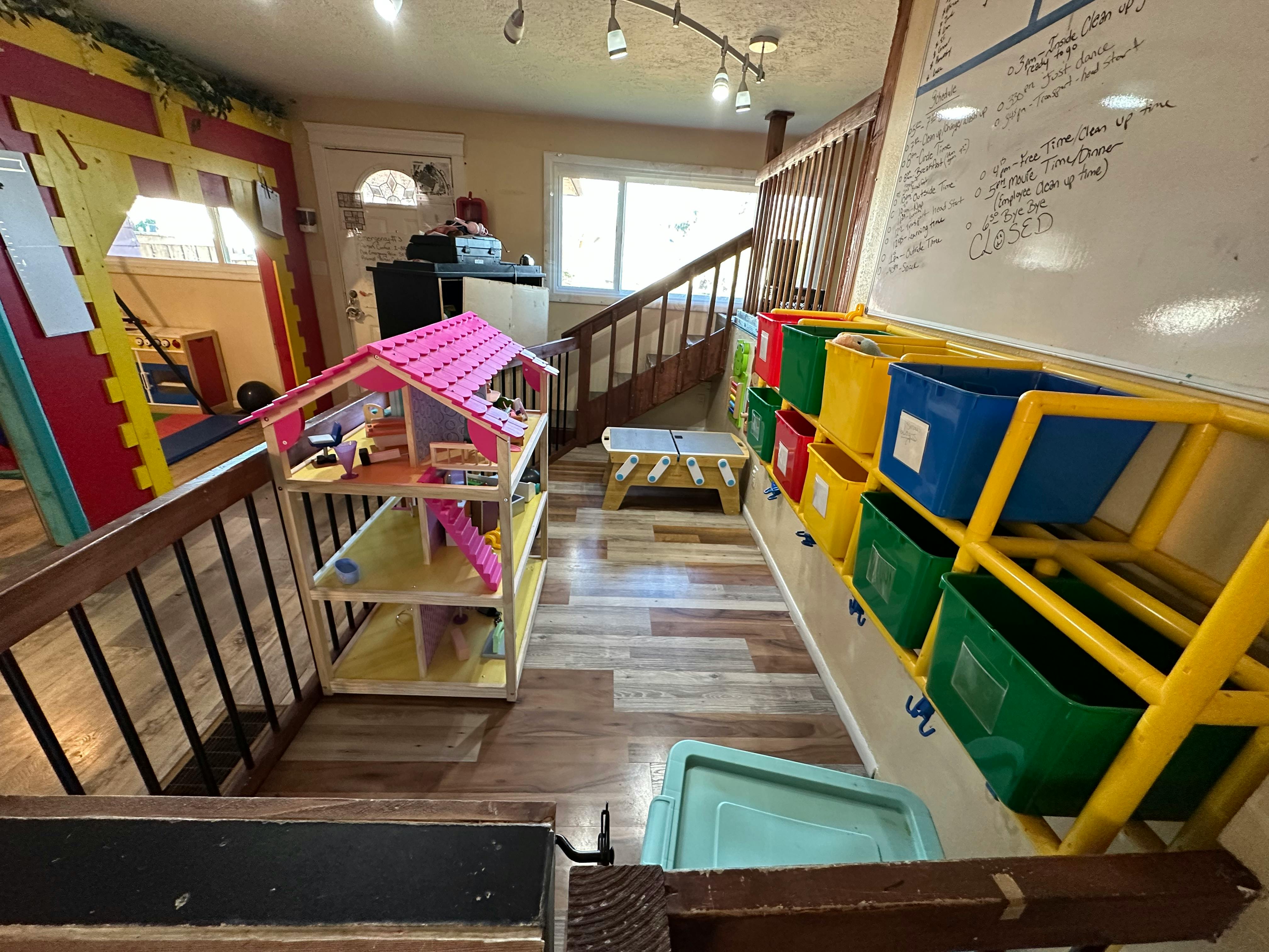 Dollhouse and storage bins on a staircase landing
