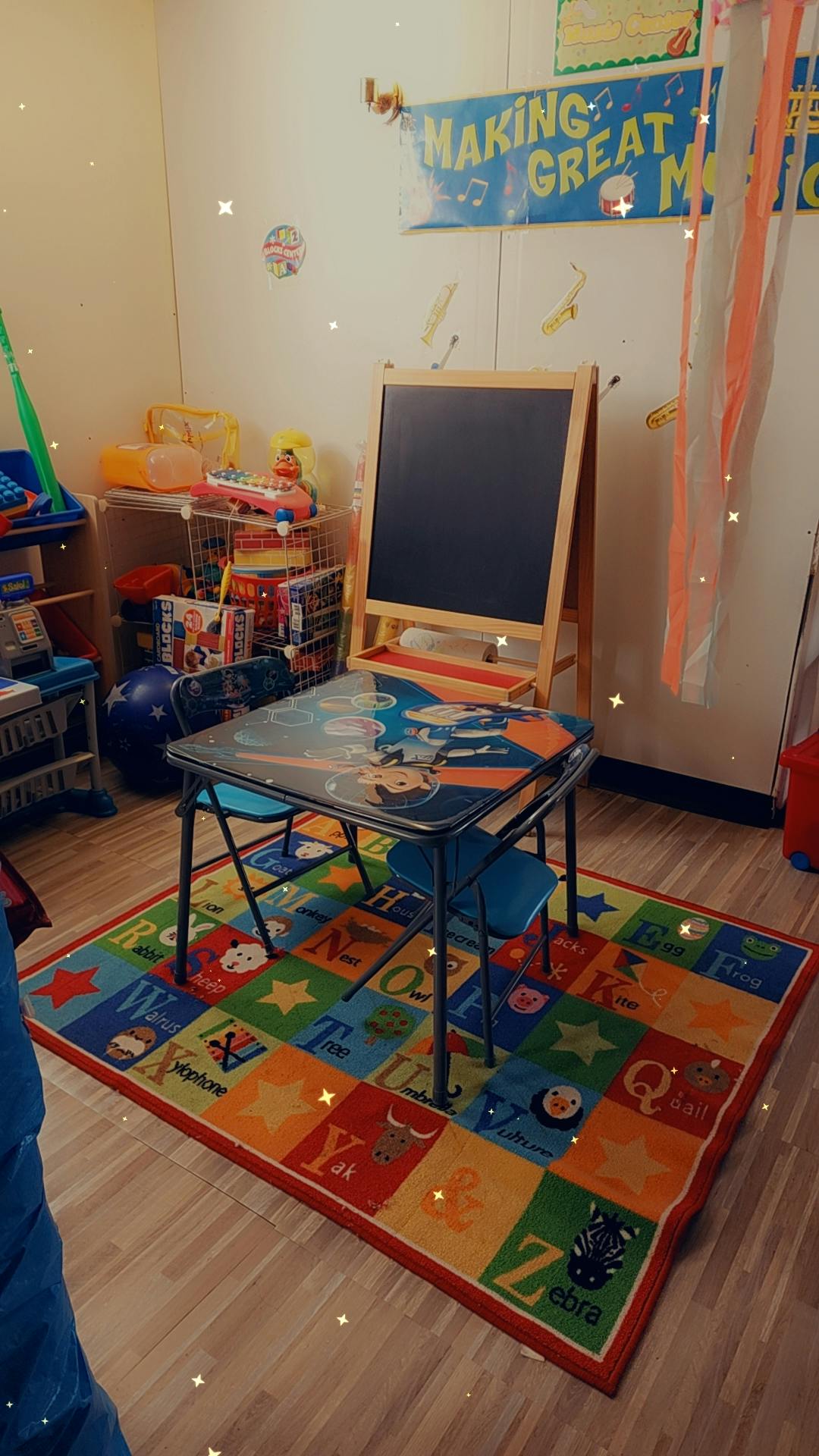 children's table and chairs with a colorful alphabet rug in a classroom