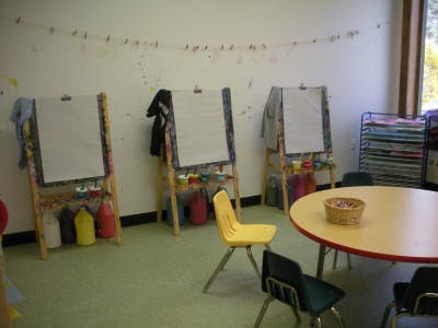 Classroom with easels, chairs, and a round table