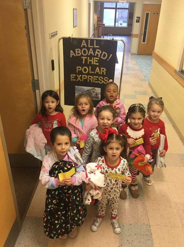 Group of children standing in a hallway with a "Polar Express" sign