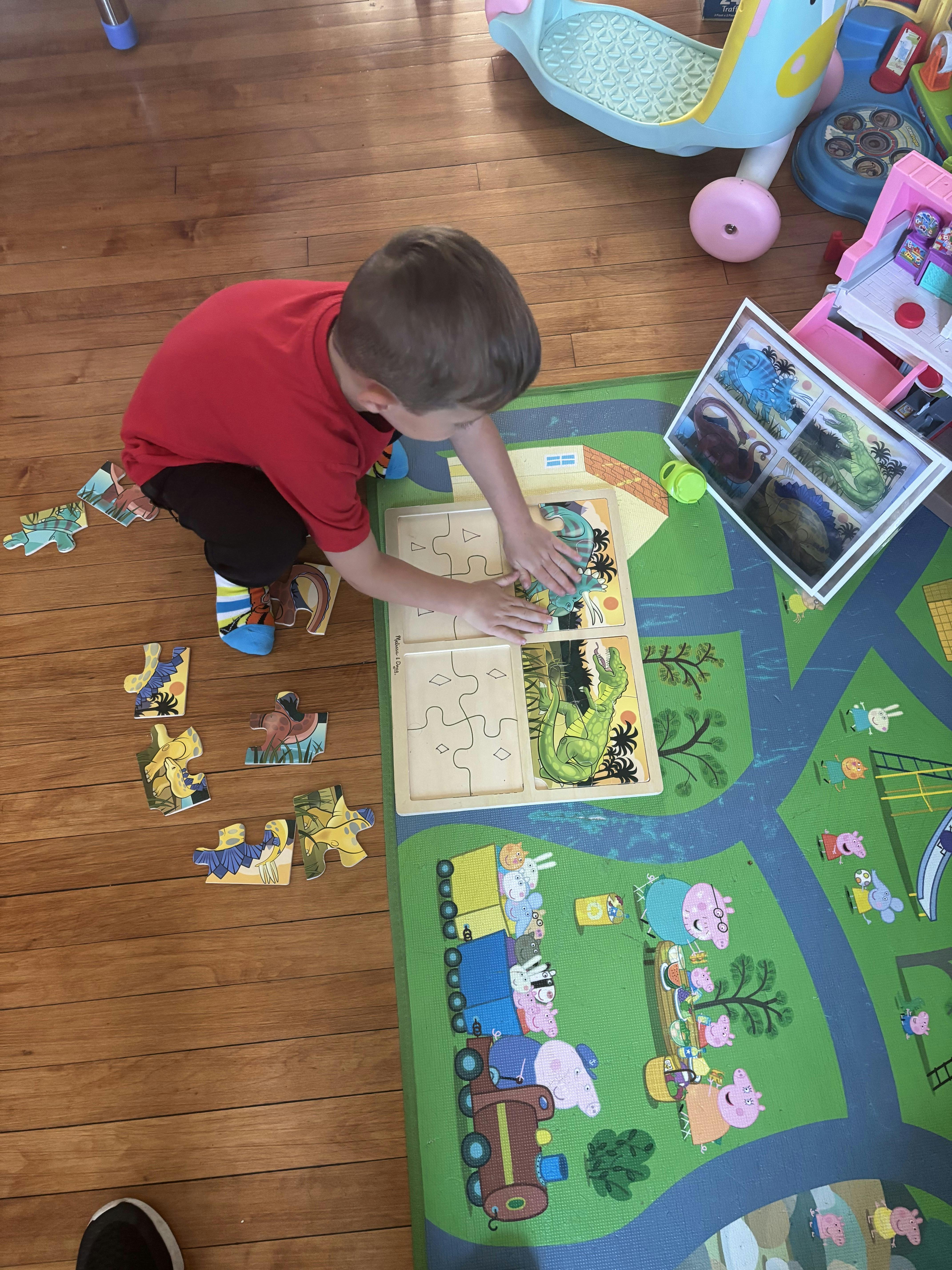 Child playing with a wooden puzzle on the floor