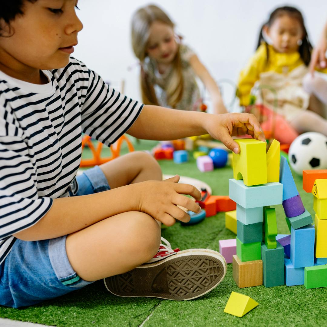 Child building with colorful blocks on a green mat