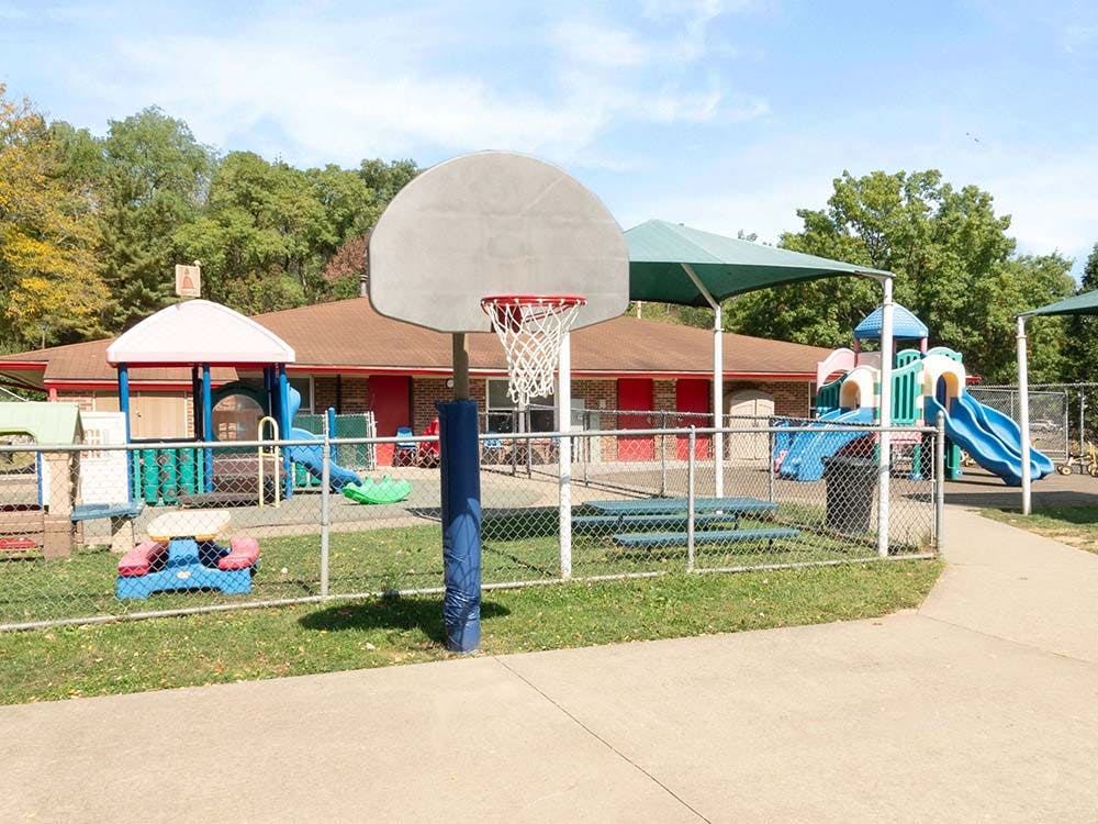 Basketball hoop with a fenced playground behind it