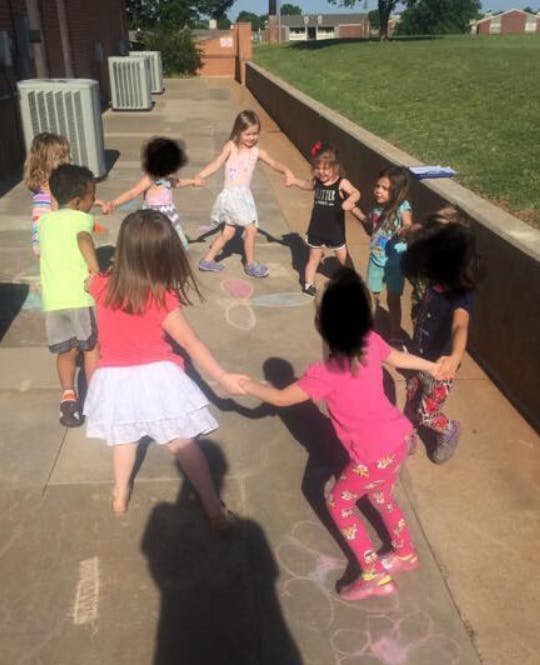 Children holding hands in a circle outdoors