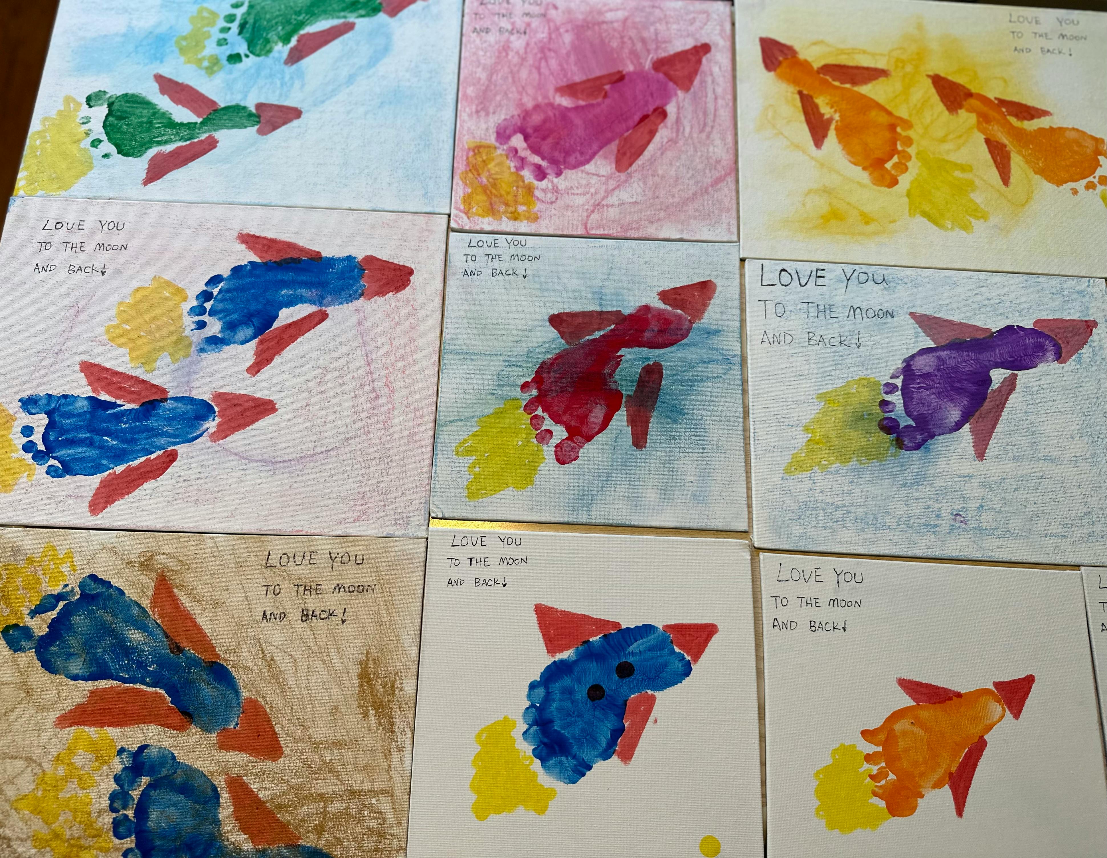 Multiple child's footprint rocket crafts on paper