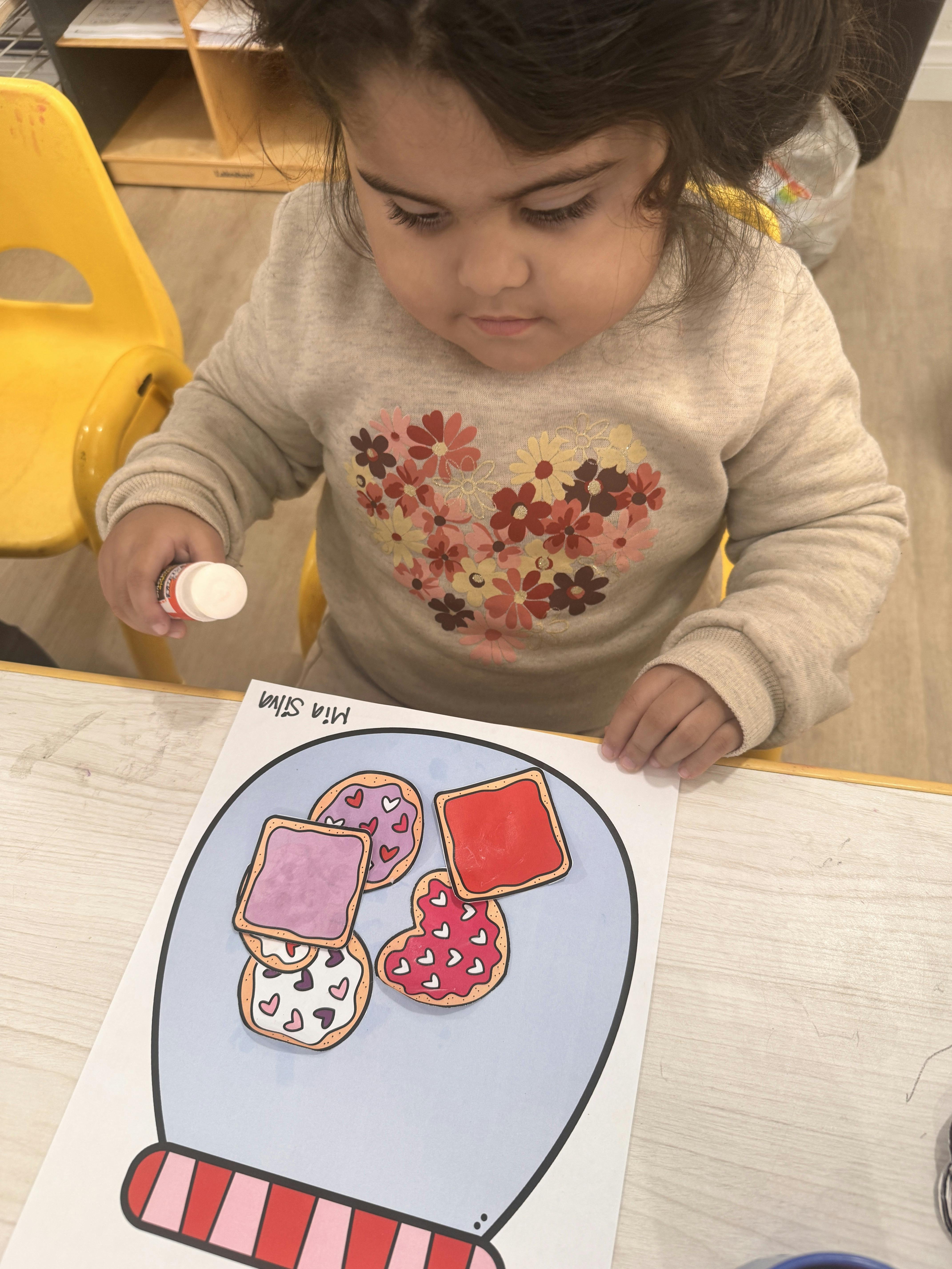 Child crafting with glue at a table