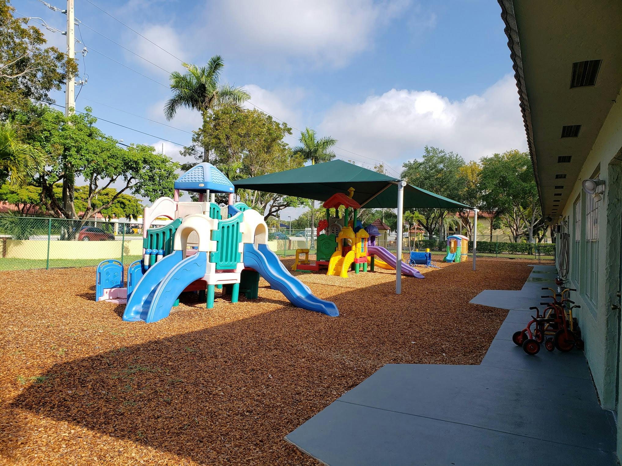 Outdoor playground with slides and climbing structures on wood chips