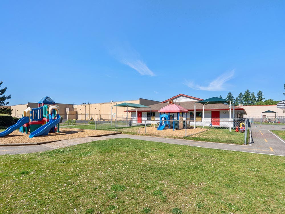 Playground with swings, slides, and outdoor play equipment at a school
