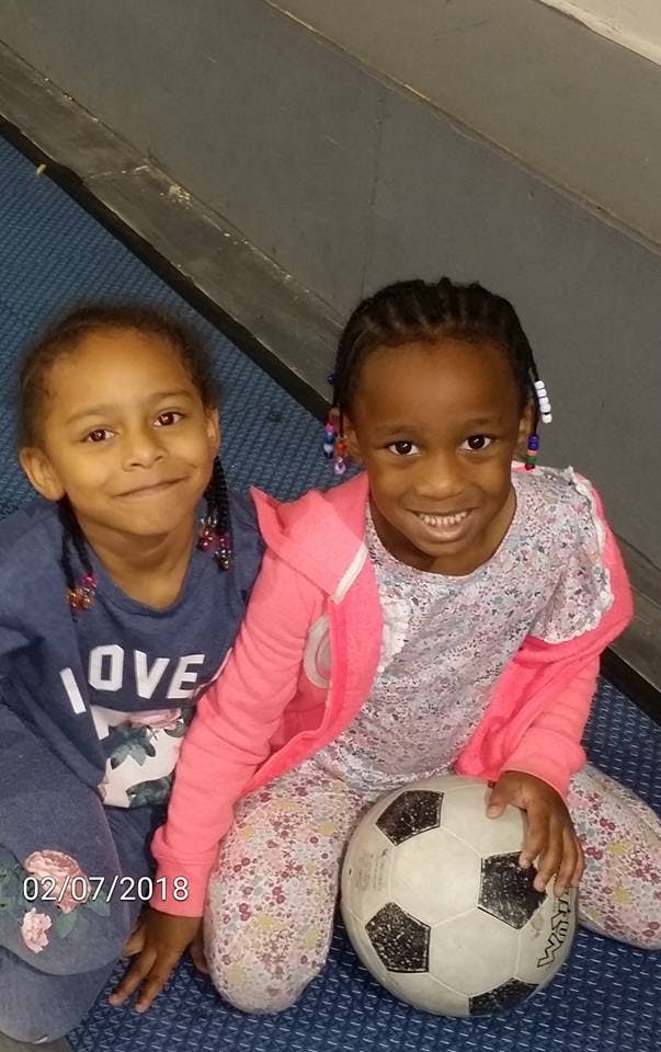 Two children sitting with a soccer ball