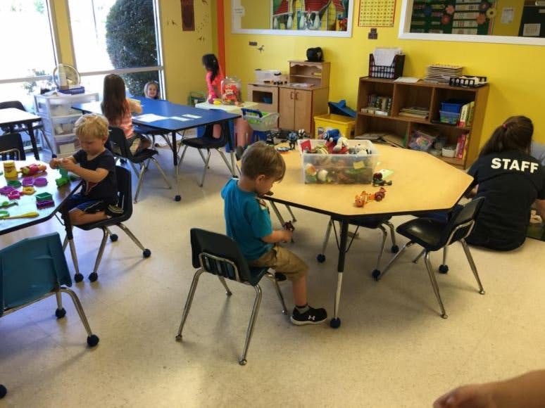Children playing at tables in a classroom