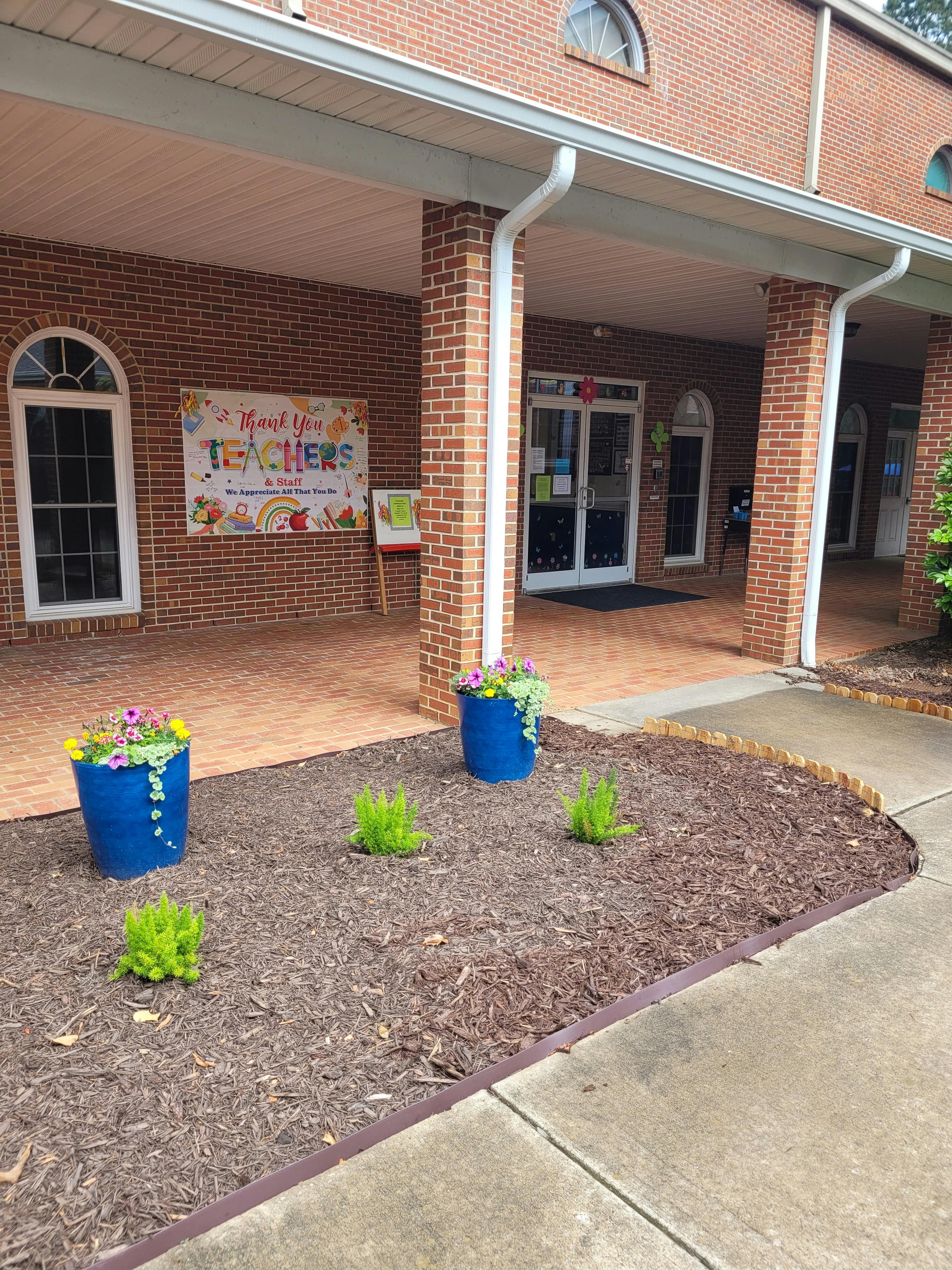 Brick building entrance with a "Thank You Teachers" banner