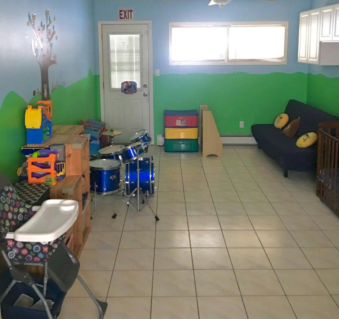 Playroom with blue drum set, high chair, and sofa