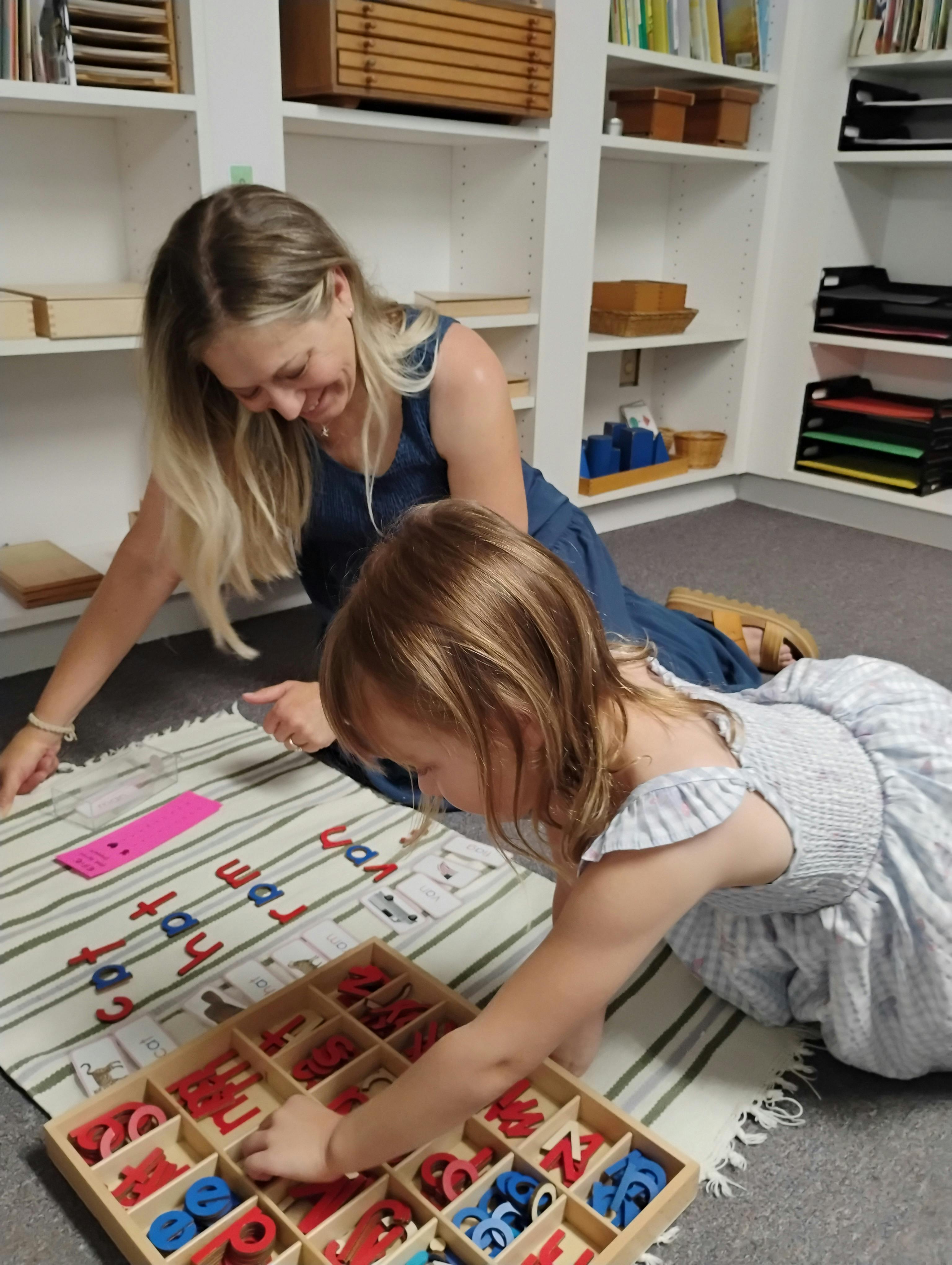 Adult and child using a wooden letter set to spell words on a mat