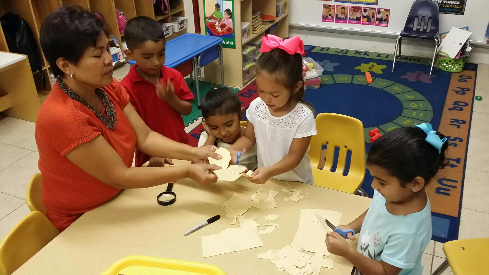 Adult and children at a table doing crafts in-class activity