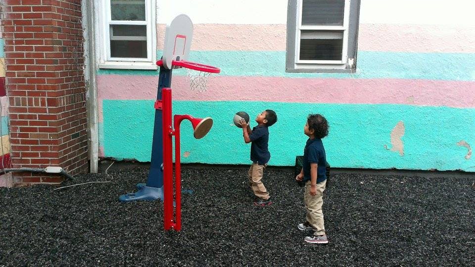 Two children playing basketball outdoors