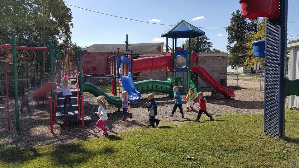 Children playing on a playground with slides and climbing structures