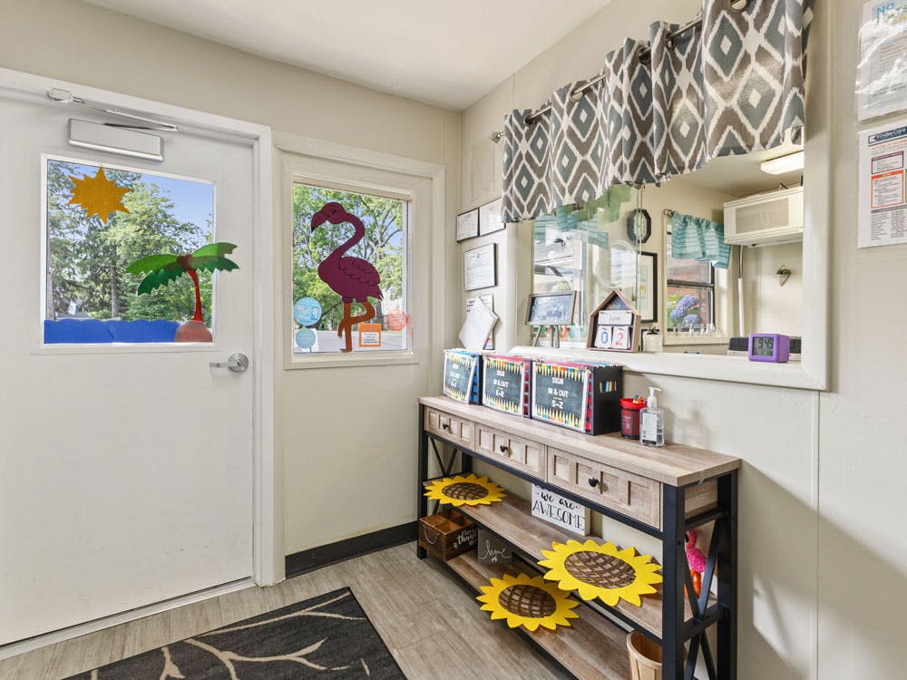 Room with decorated windows and a console table under a large wall mirror