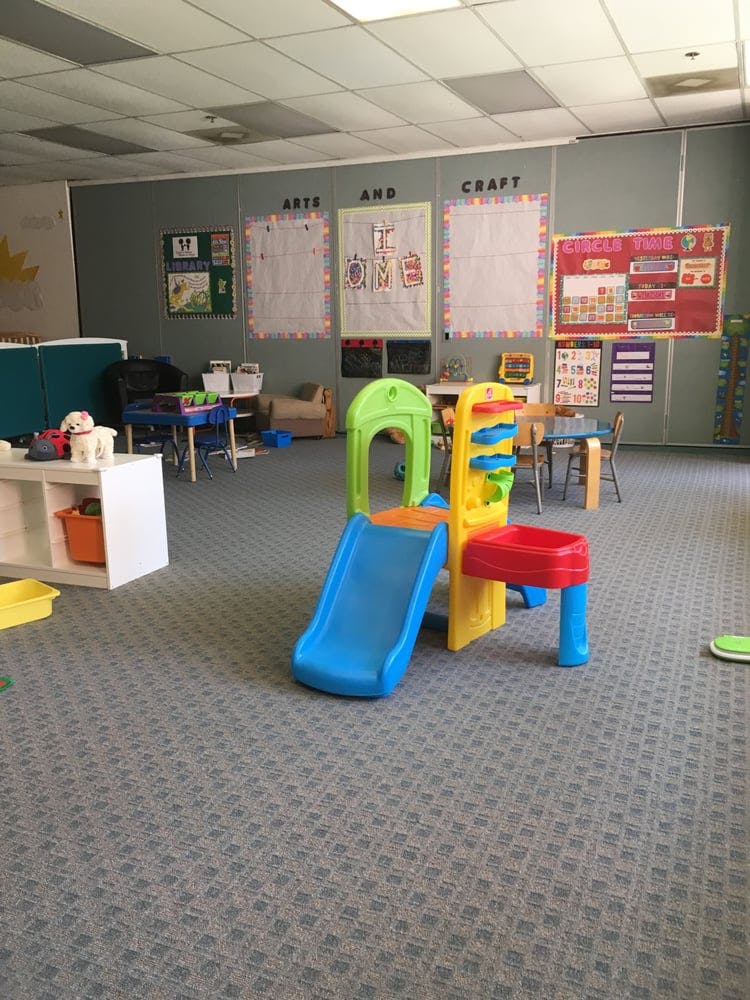 Indoor play area with a colorful plastic slide and play structure