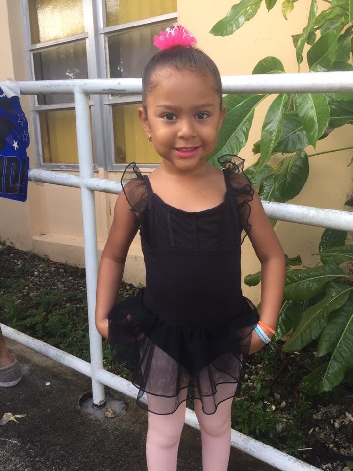 Child in a black leotard and pink tights with a pink tiara