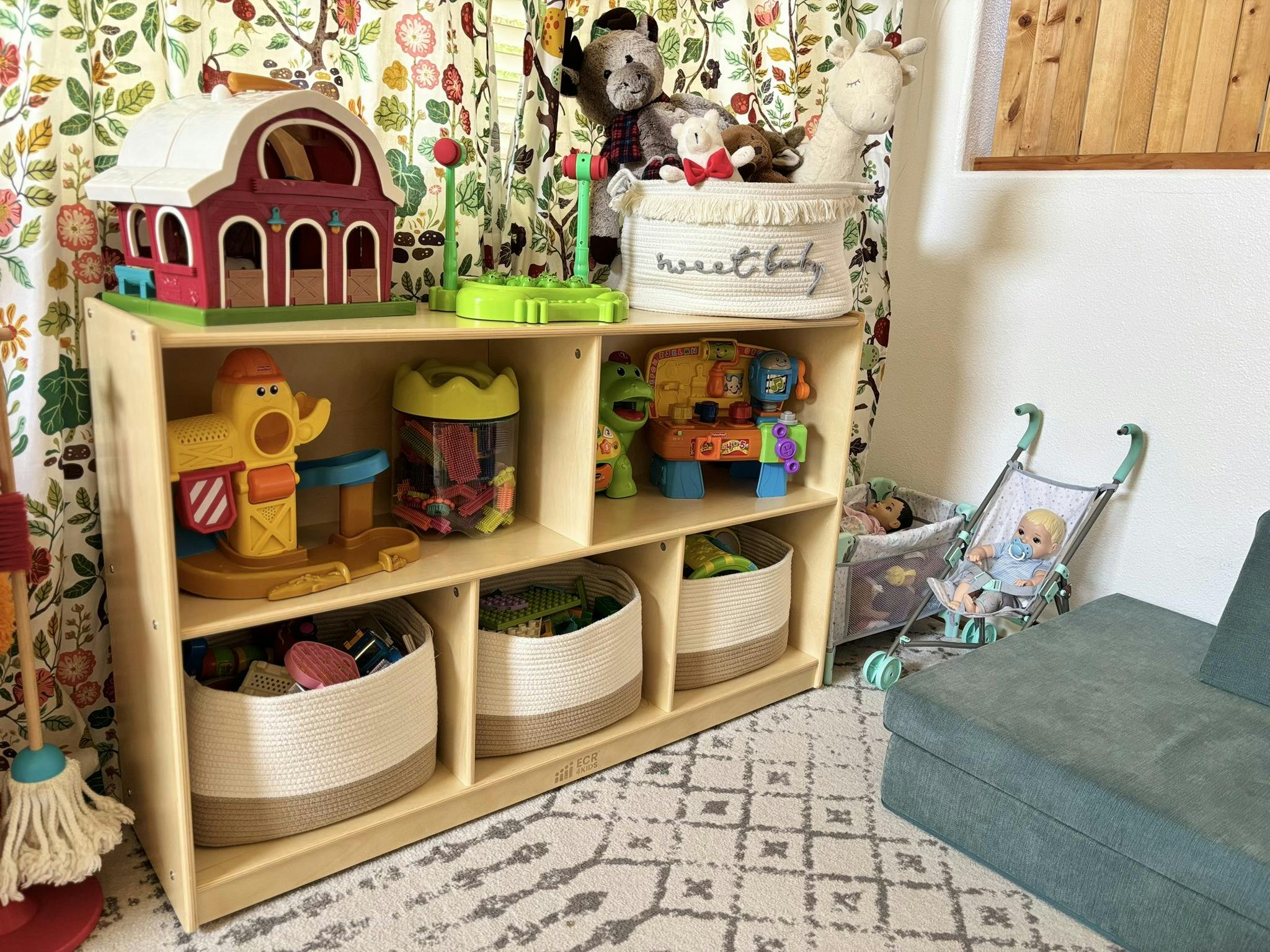Wooden toy shelf with various toys and storage bins