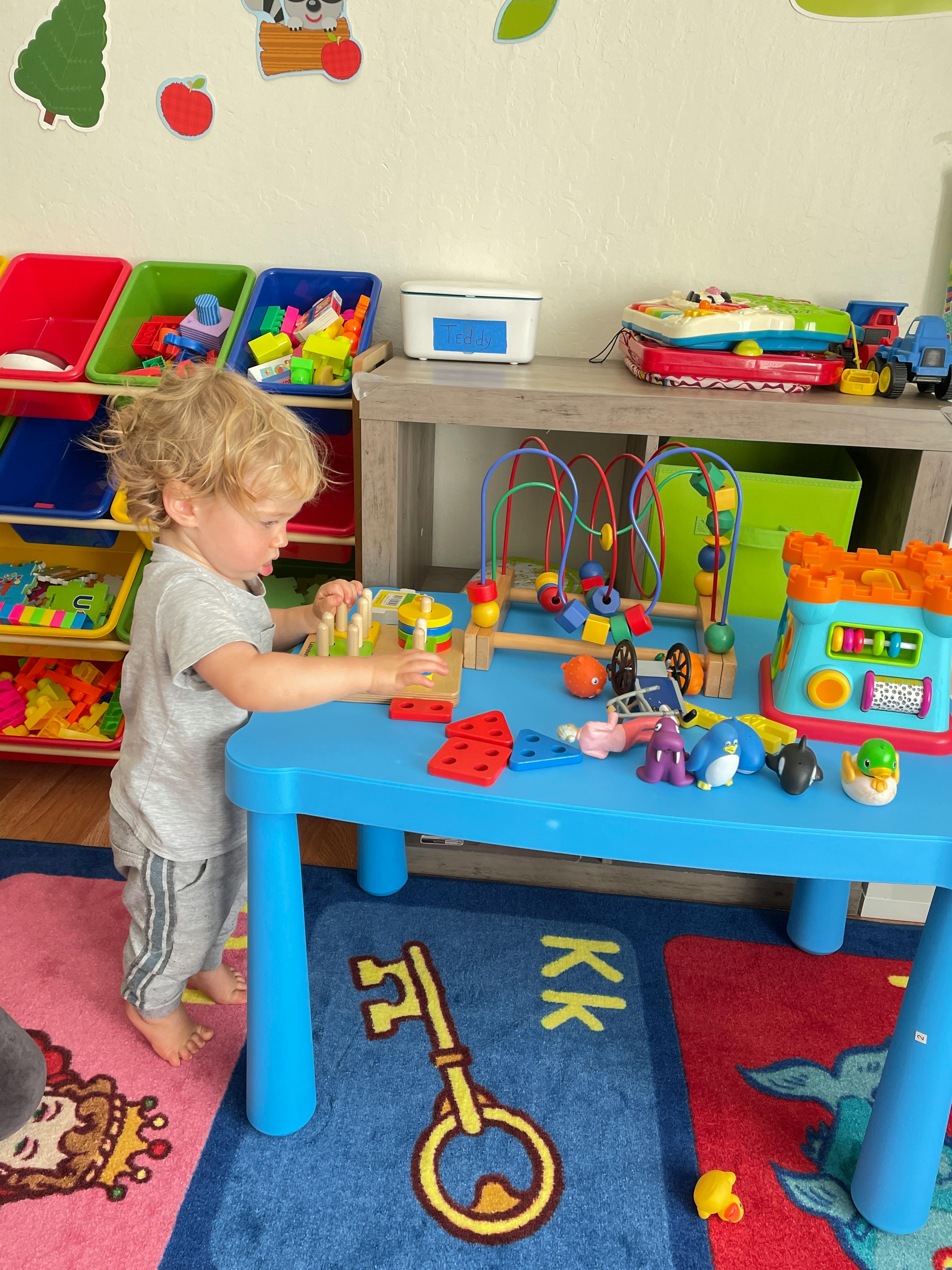 Child playing with toys at a blue table