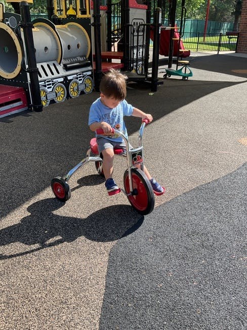 Child riding a tricycle on a playground