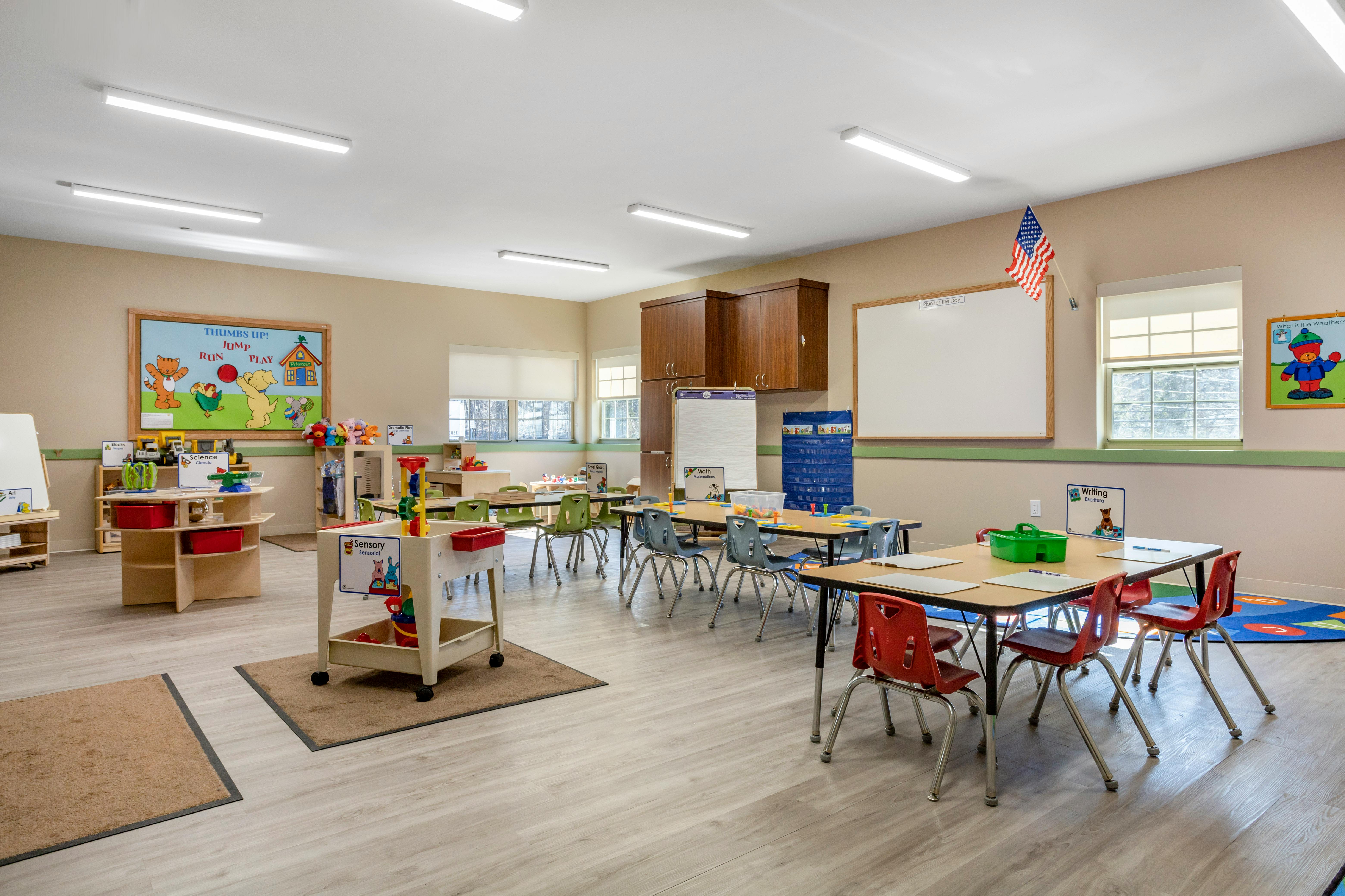 Classroom with tables, chairs, and learning stations