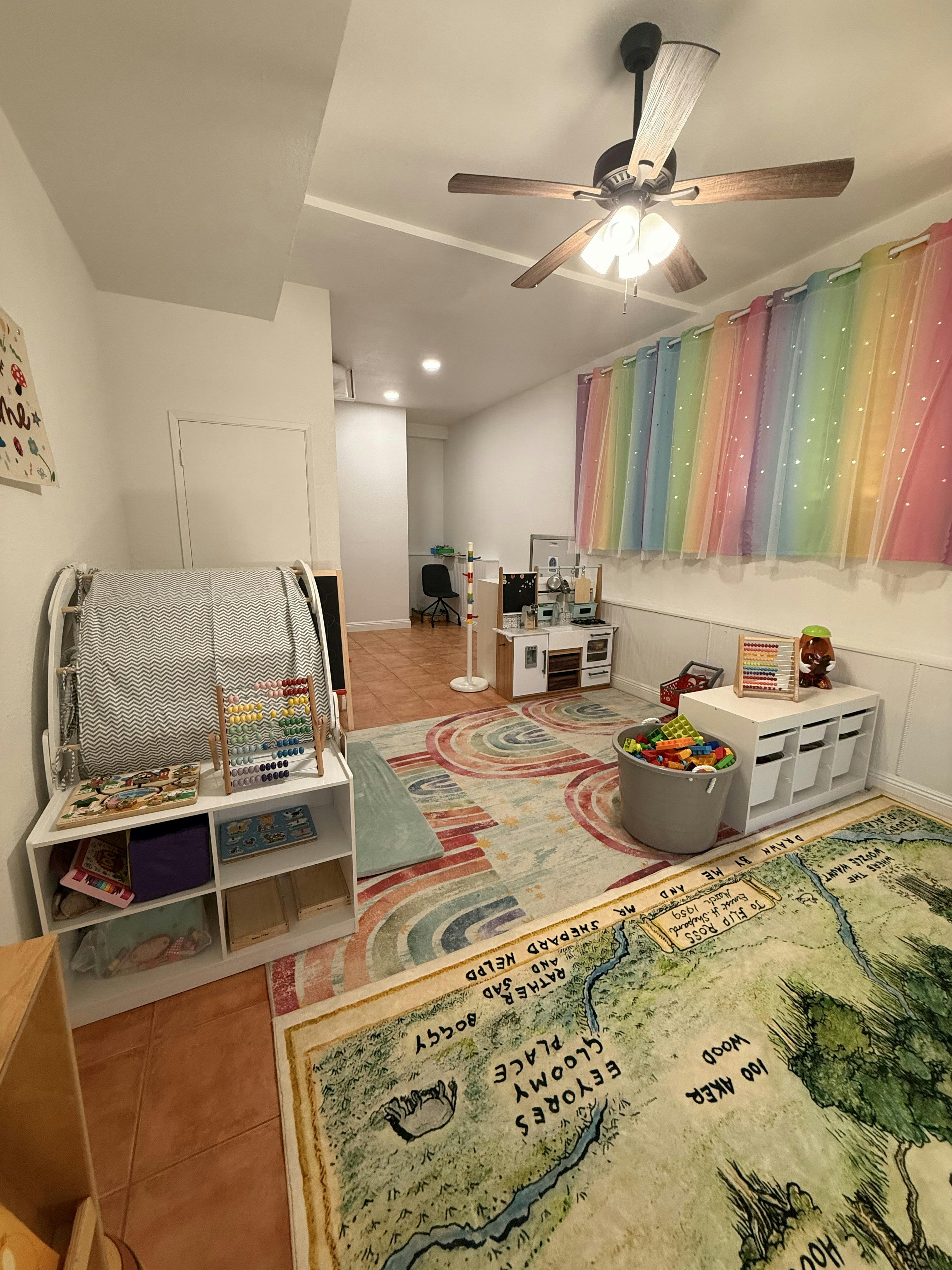 Playroom with children's toys and furniture including a rug with a map design