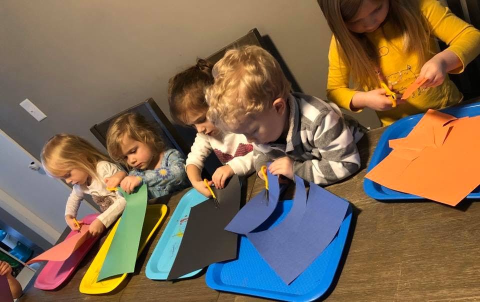 Children cutting paper with scissors