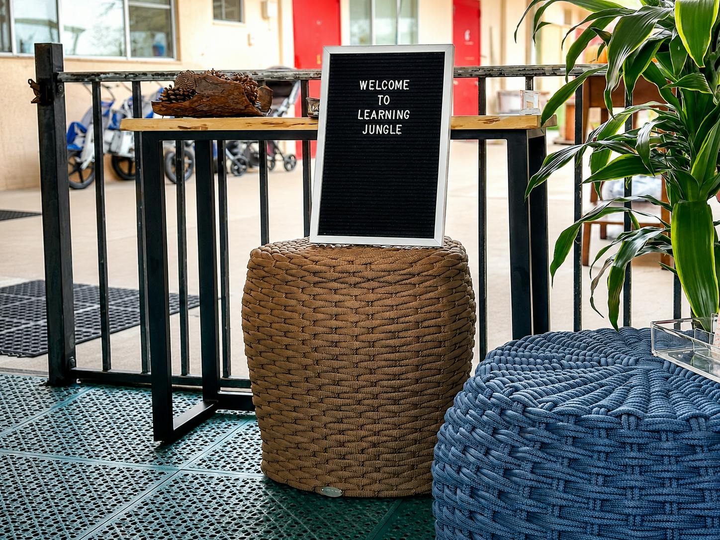 Sign reading Welcome to Learning Jungle placed on a woven stool