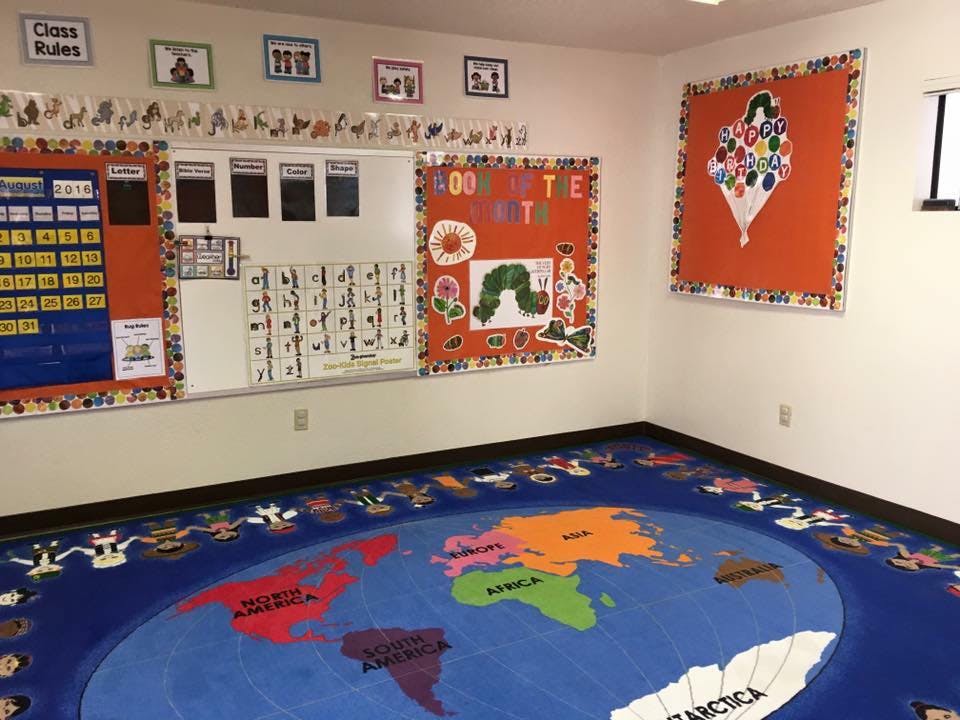 Classroom with a world map rug and bulletin boards