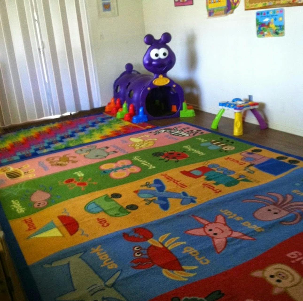 Colorful playroom with a caterpillar tunnel and an alphabet rug